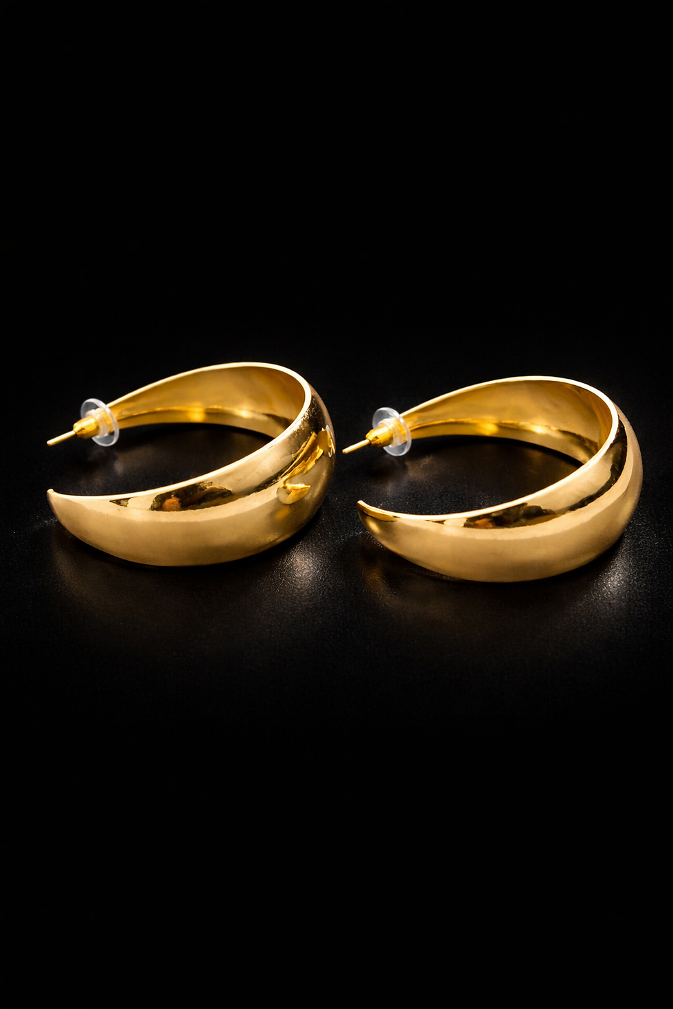 Bold gold dome hoop earrings on white background