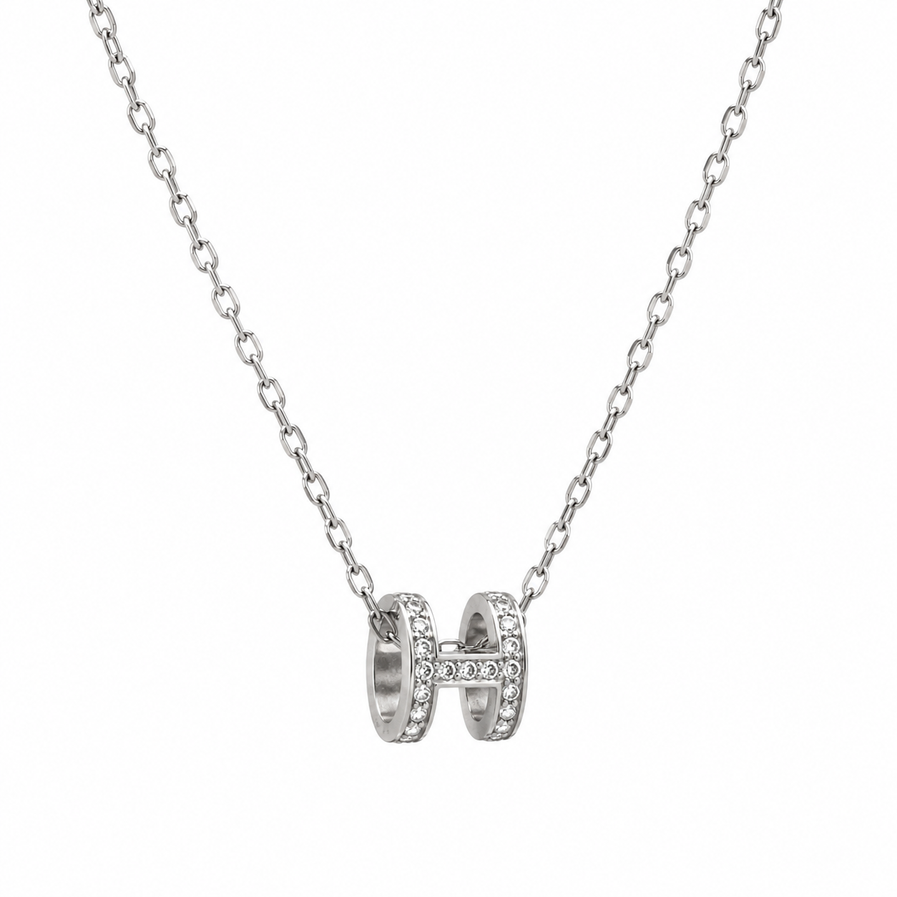 Silver H pendant with a white background