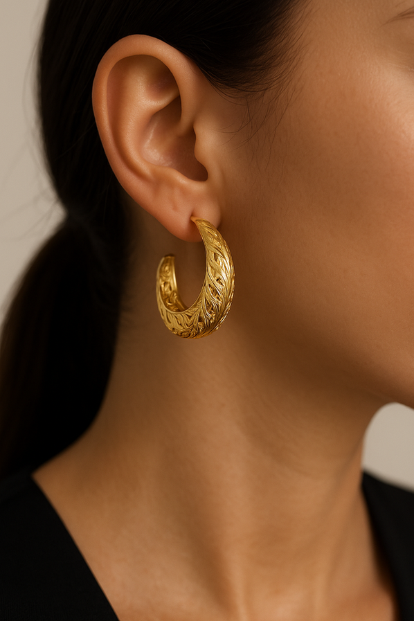 Model wearing Nova textured gold hoop earrings with carved tribal-inspired detailing.