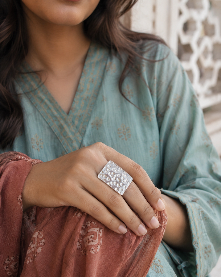 Woman wearing adjustable square gold brass ring