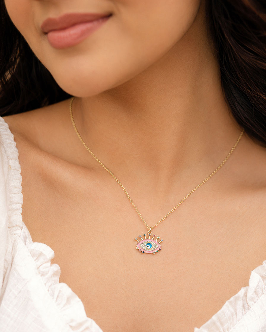 Indian model wearing a pink crystal evil eye pendant necklace with a delicate gold-tone chain