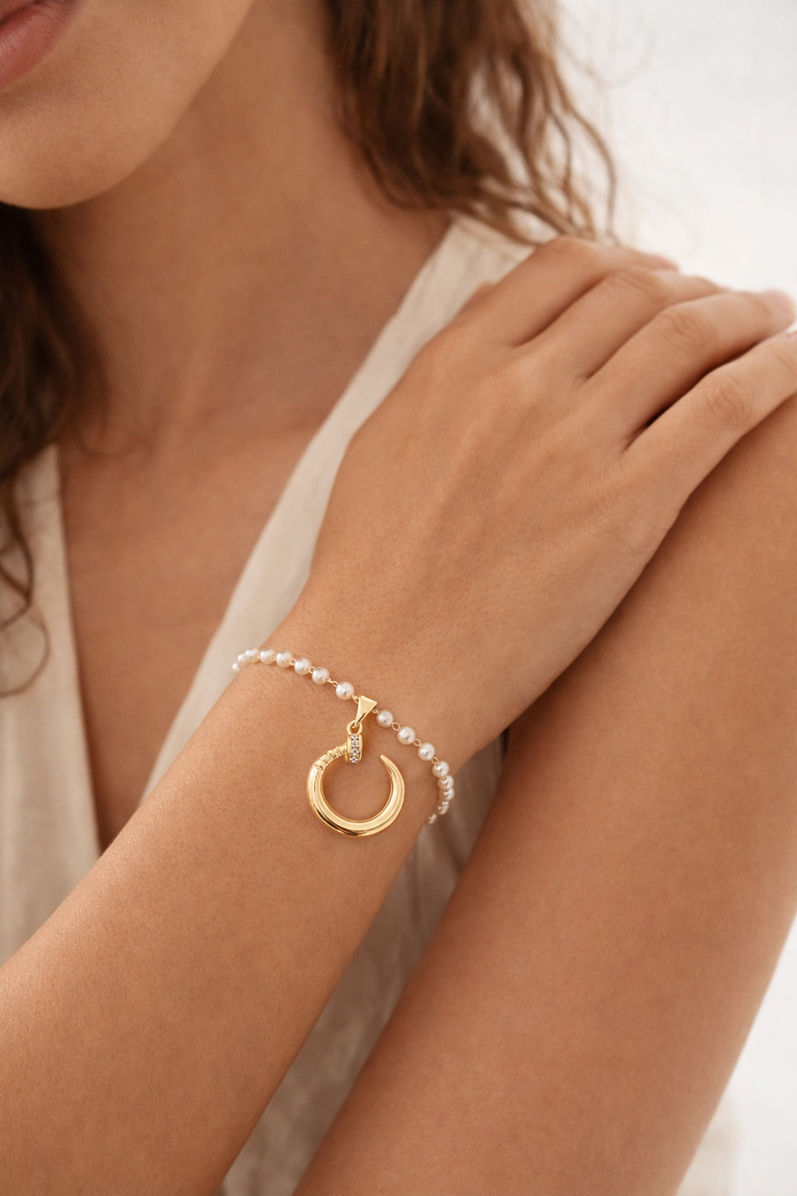 Gold tone charm bracelet with pearl detailing for everyday wear