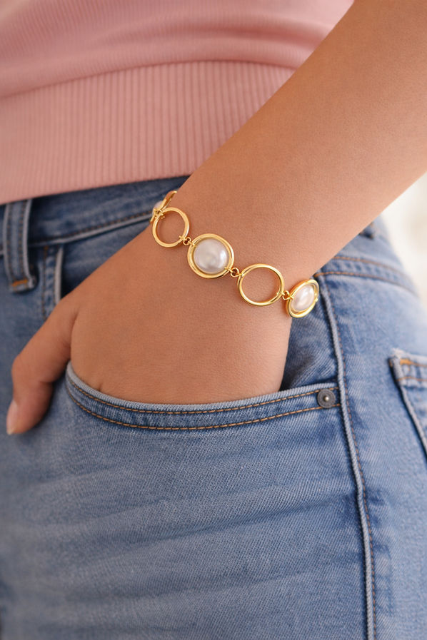 Gold tone pearl link bracelet with open circle design