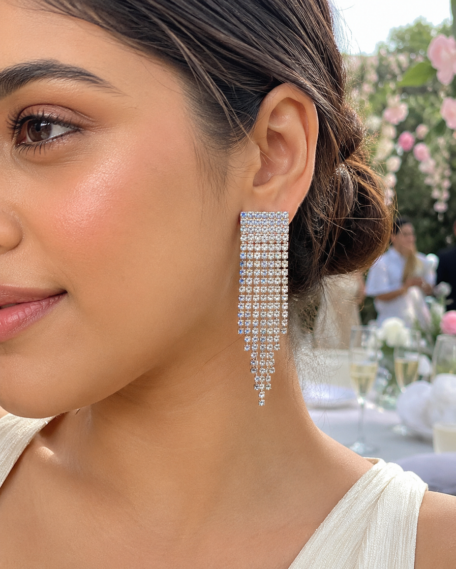 Woman wearing silver crystal waterfall dangler earrings at an evening party