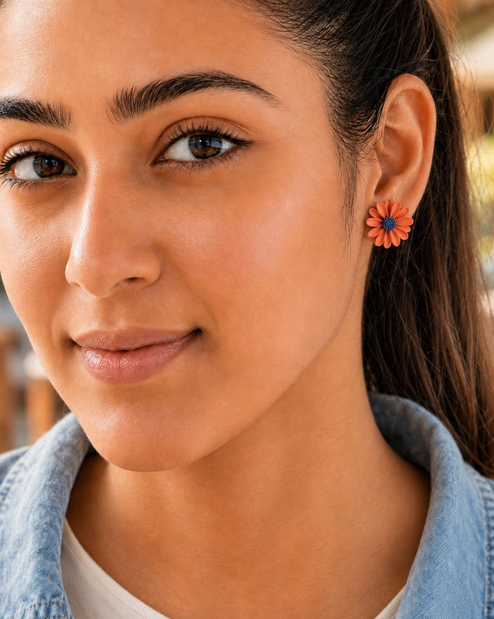 Woman wearing mismatched Korean floral stud earrings in orange