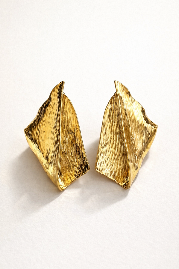 Abstract gold stud earrings with bold sculpted shape and textured finish