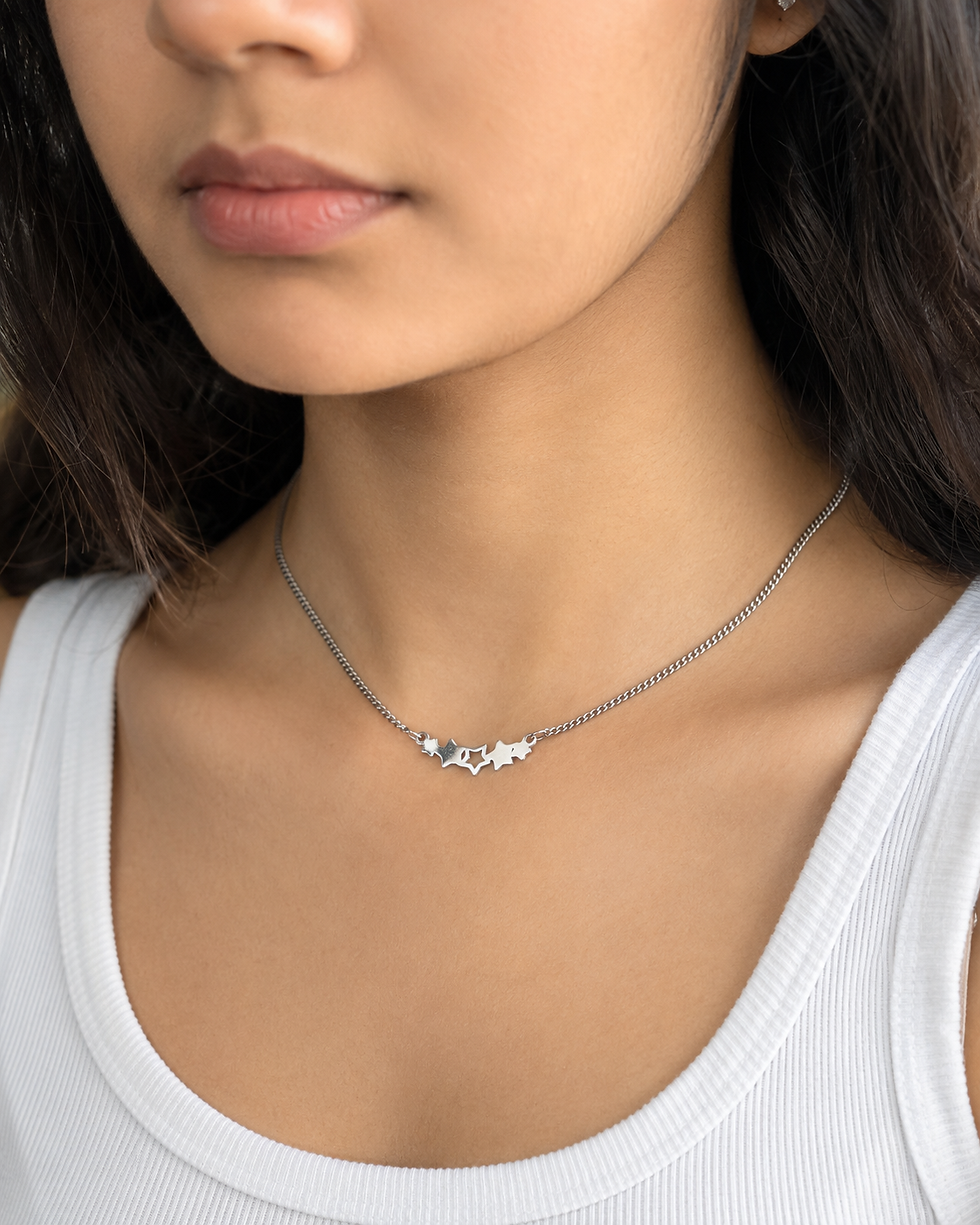Indian model wearing short stainless steel star necklace with casual top