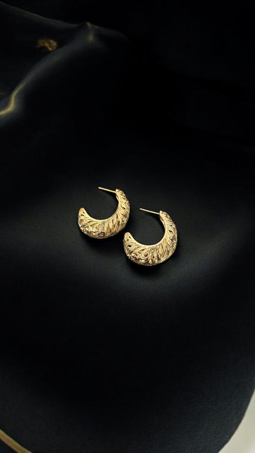 Model wearing Nova textured gold hoop earrings with carved tribal-inspired detailing.
