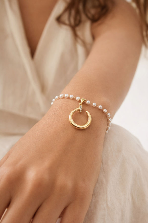Lightweight pearl charm bracelet with gold tone crescent pendant