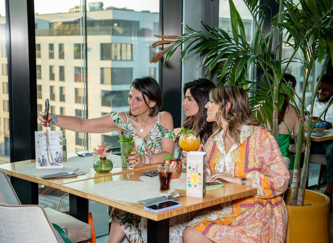 un groupe de filles se prenant en selfie à BUBBLIES autour d'un cocktail