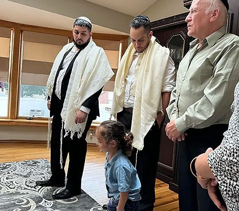 Bris Milah circumcision ceremony with family and Mohel present.