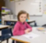 MCA female elementary student studying in class