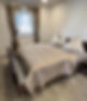 Gemütliches Schlafzimmer mit Doppelbett und beigefarbener Bettdecke