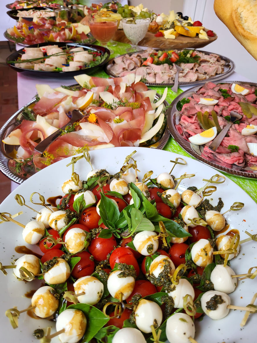 Reichhaltiges Buffet mit Käse, Aufschnitt und Caprese-Spießen