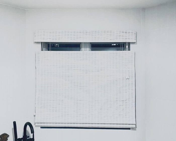 White woven wood shade in a bathroom