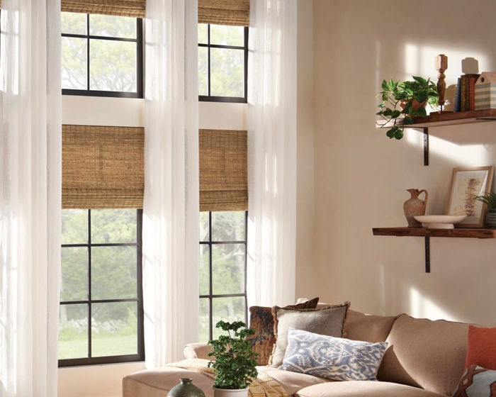 Woven wood shades with sheer drapery on tall windows