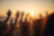 cheering-crowd-with-hands-in-the-air-summer-vacation-image-bokeh-people-have-fun-at-sunset