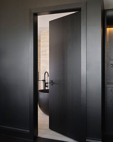 porte intérieure en bois noire, mur noir et bain noir