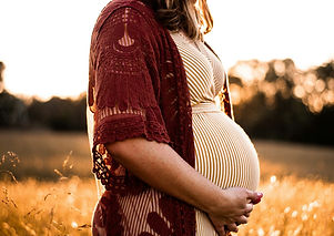 woman in a field holding her stomach