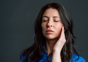 woman relaxing while holding a hand to her face
