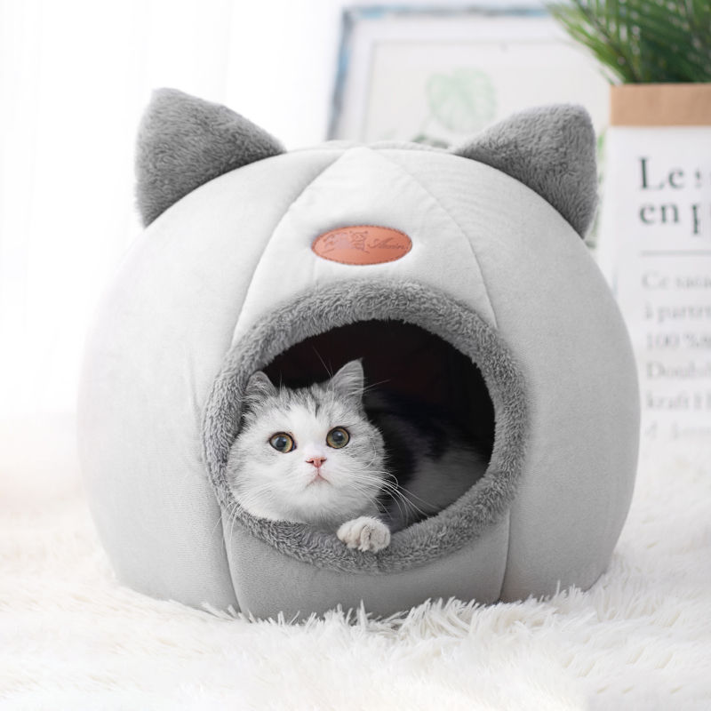 Fluffy cat in a grey deep sleep winter cat bed house.