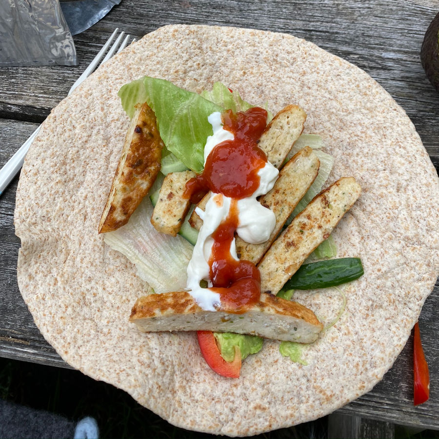 Tortilla wraps med stekte fiskekaker i biter, agurk, avokado, paprika, salat, rømme og tacosaus