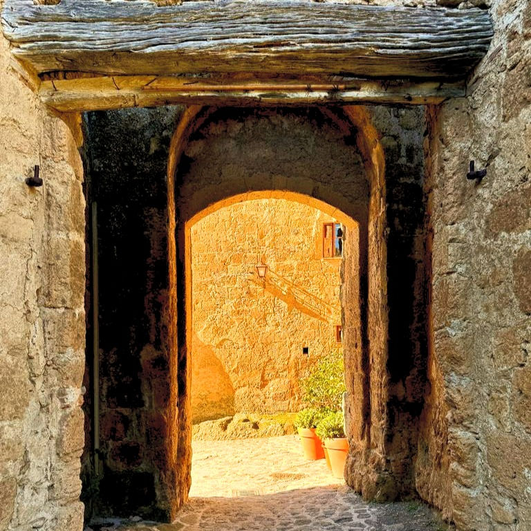 Blick durch das Tor in den Sonnengefluteten Hof