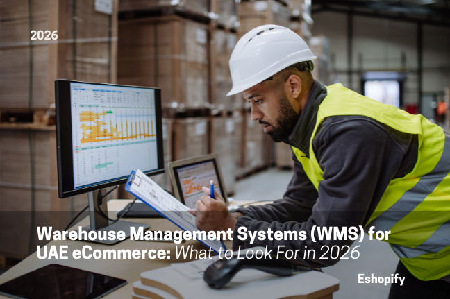 Warehouse worker in hard hat checks clipboard beside monitors in a warehouse; overlay reads 2026 and WMS for UAE eCommerce.