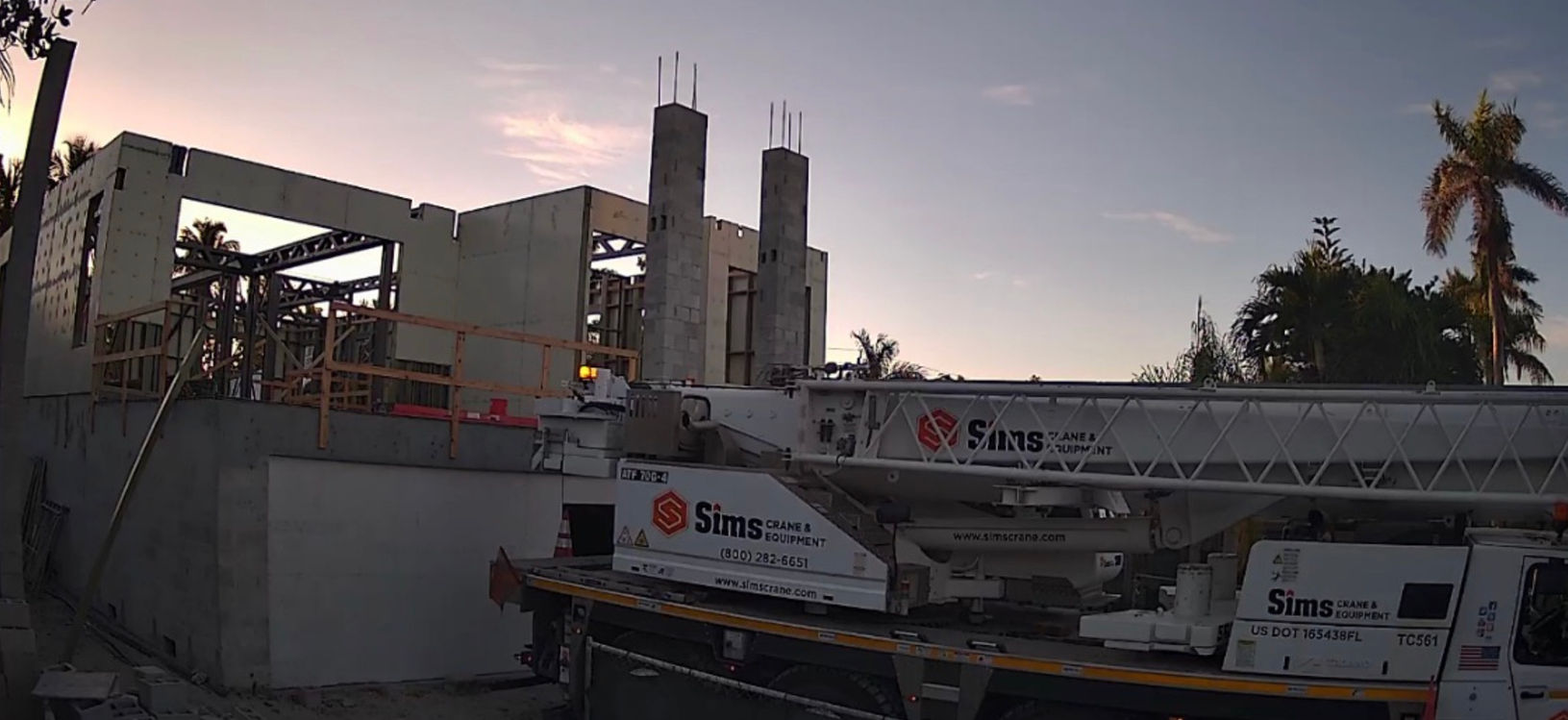 Construction site crane lifting material at dusk, with visible text and Northstar Building Systems.