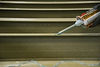 Hand applying adhesive to a grooved surface