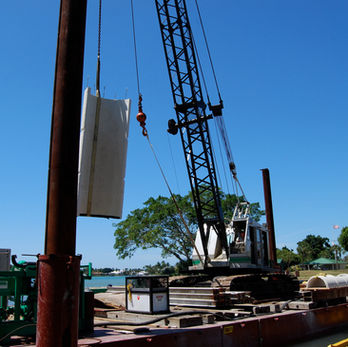 Crane lifting a large white object.