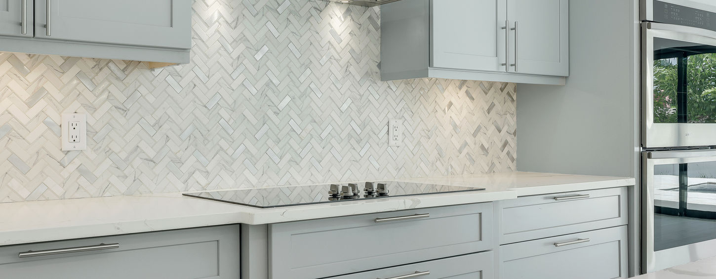 Modern kitchen with gray cabinets and a stainless steel range hood