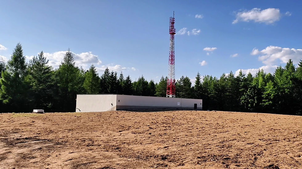 Cell tower and building in a field.