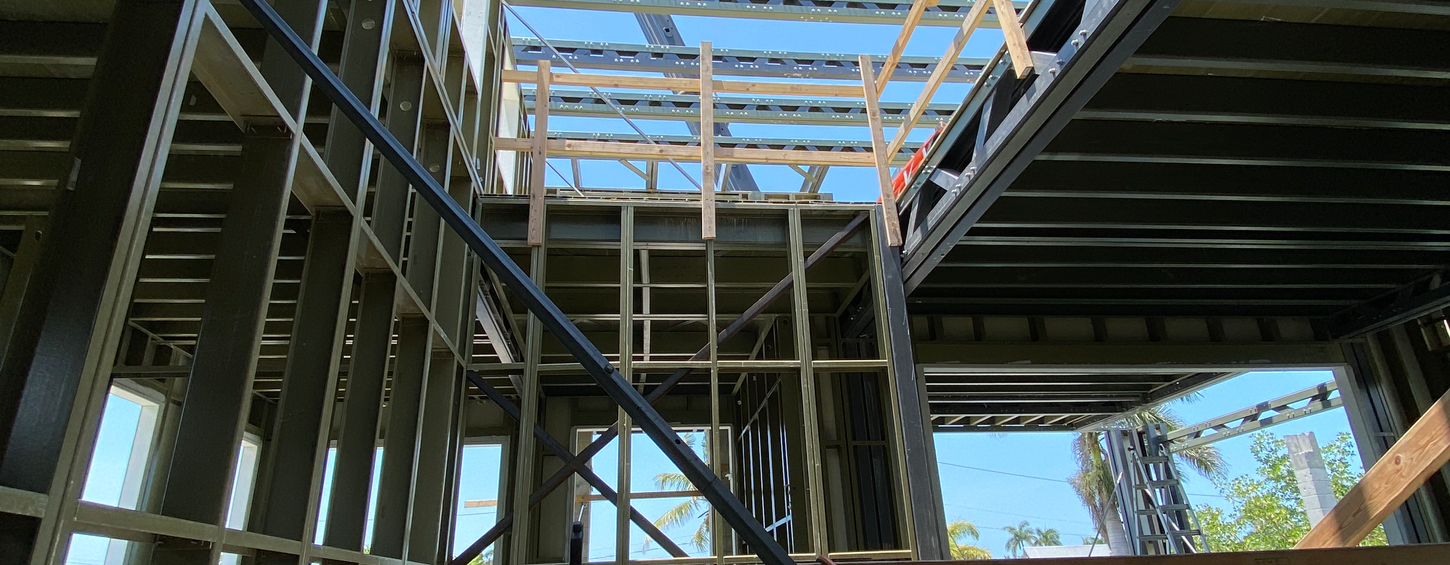 Construction framework with wooden beams and structural supports with open blue sky