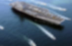 Aircraft carrier at sea with escort ships