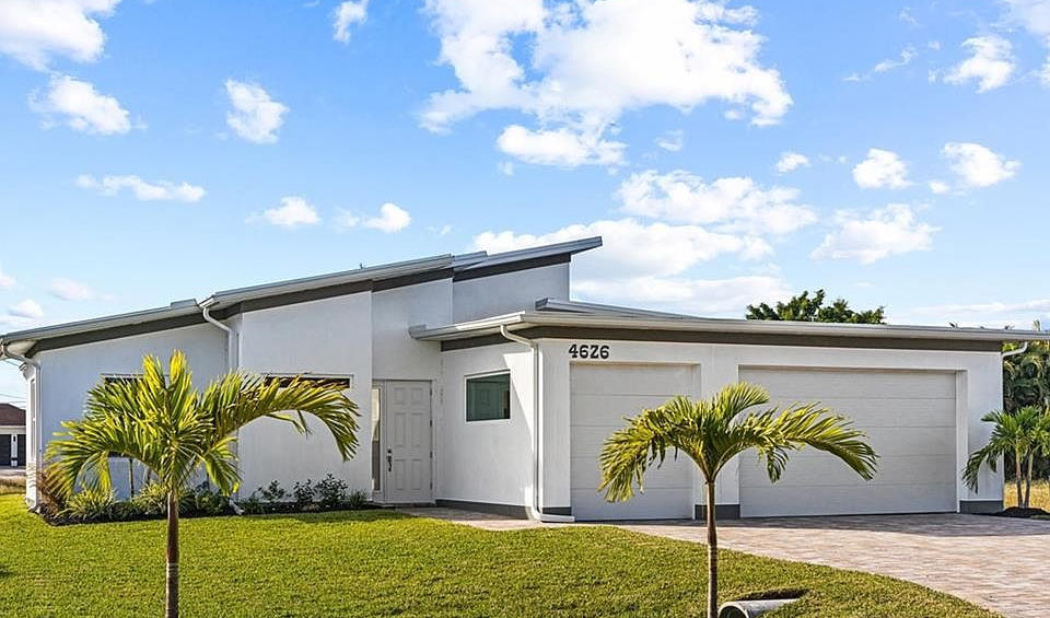 Modern home exterior with white walls and green lawn