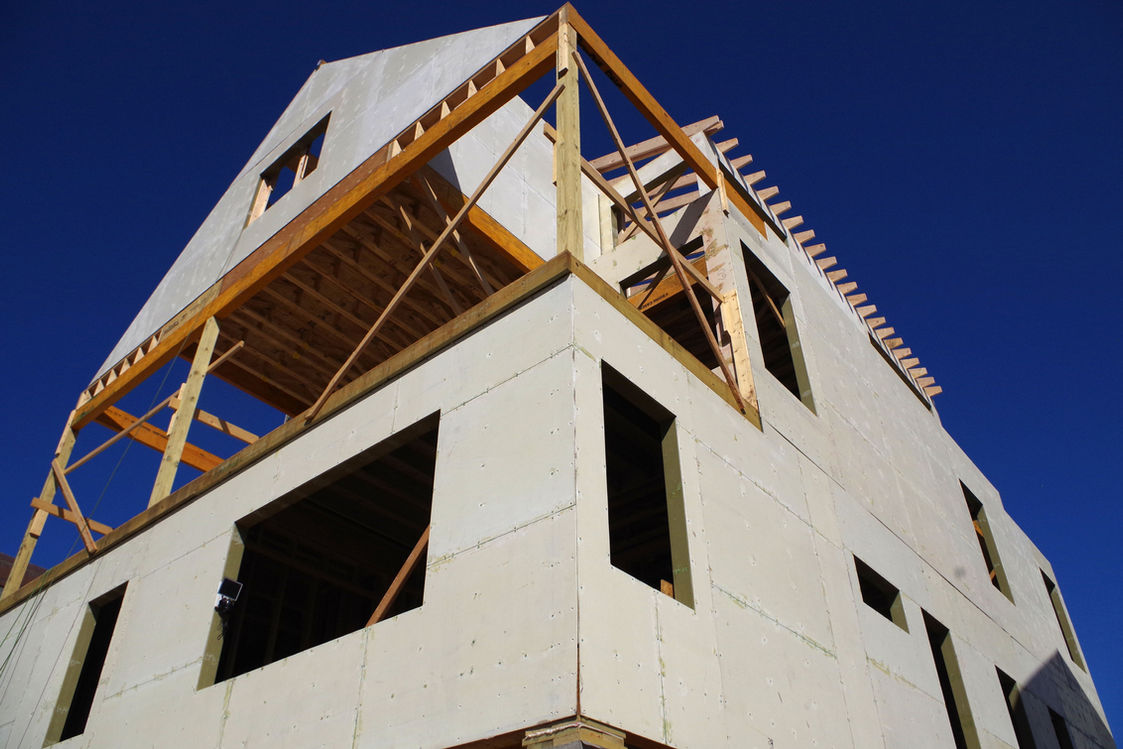 House under construction with wood frame and blue sky background