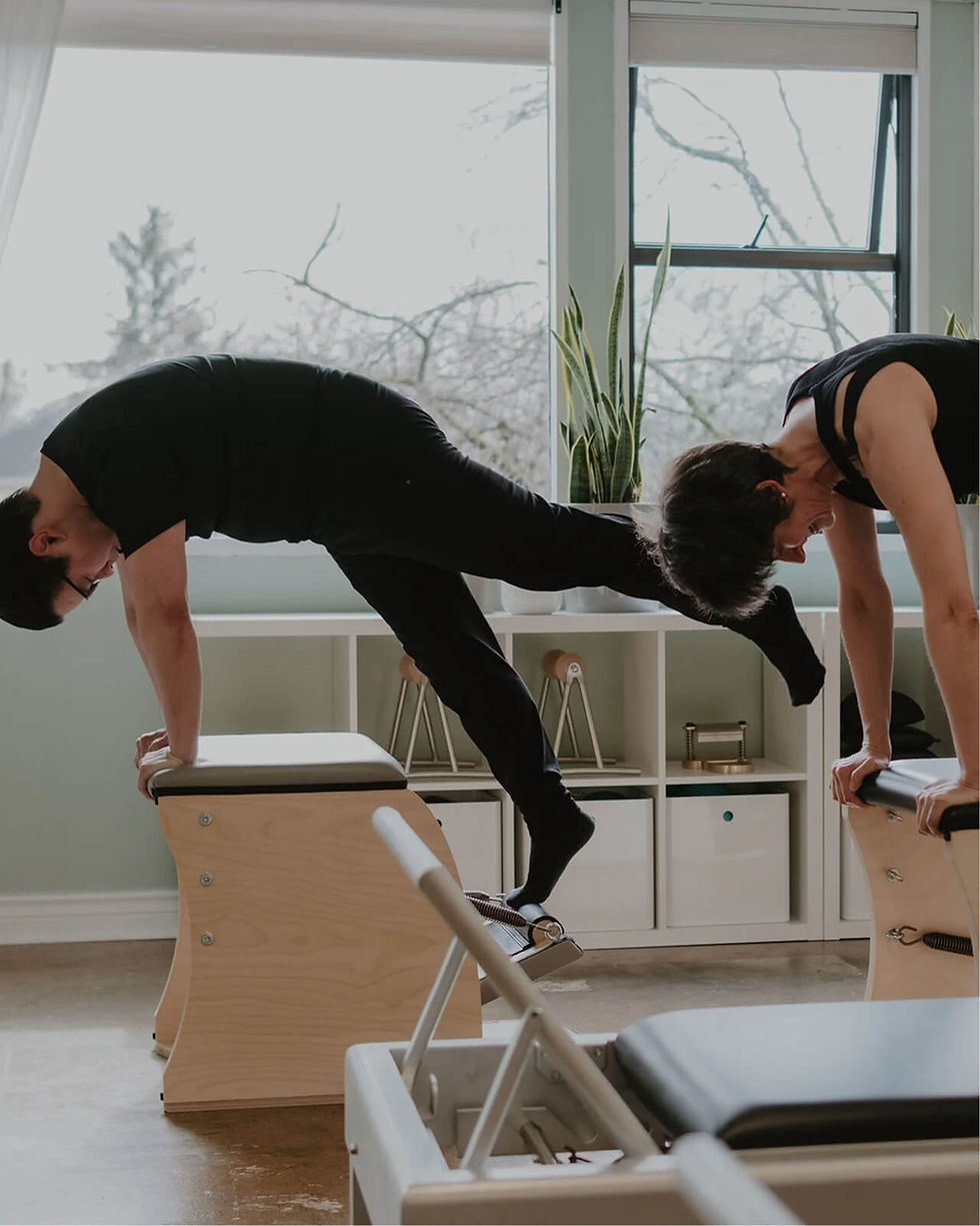 Pilates instructor demonstrating an exercise on a reformer