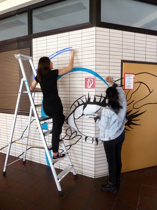 Schülerinnen bemalen die Buffetaußenseite