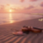 Violin and vinyl record on a sandy beach at sunset.