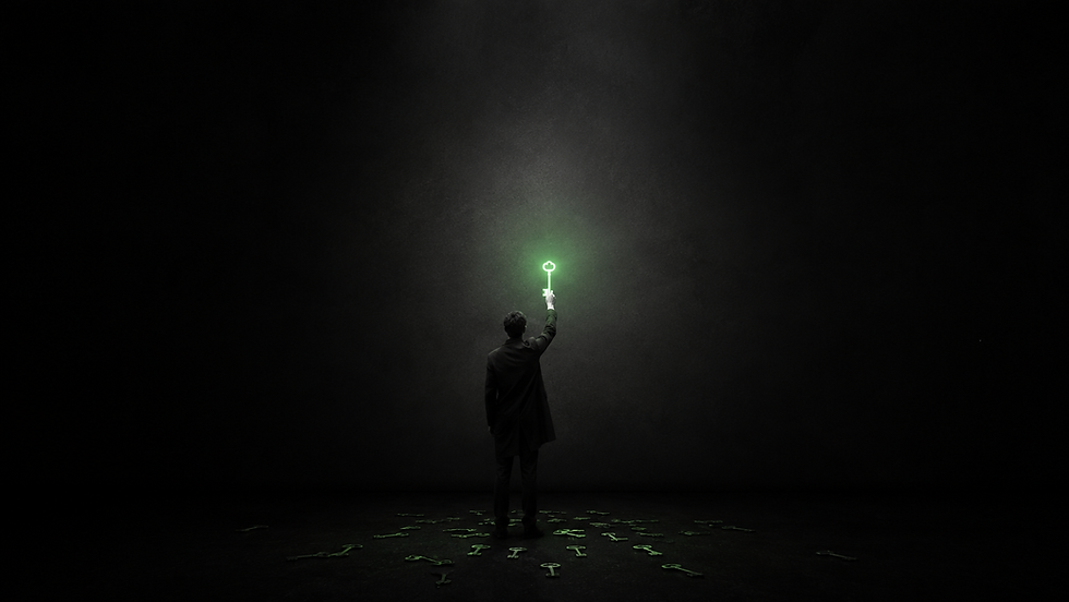 A figure in a dark room holding up one glowing green key while identical dim keys lie scattered on the floor