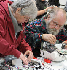 man and woman working on sewing machine