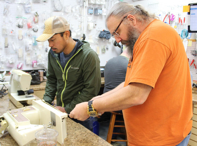 apprentice training under a sewing machine repair technician