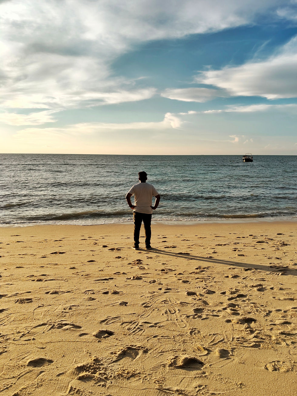 Person deeply reflecting about his leadership style in a beach in Malaysia