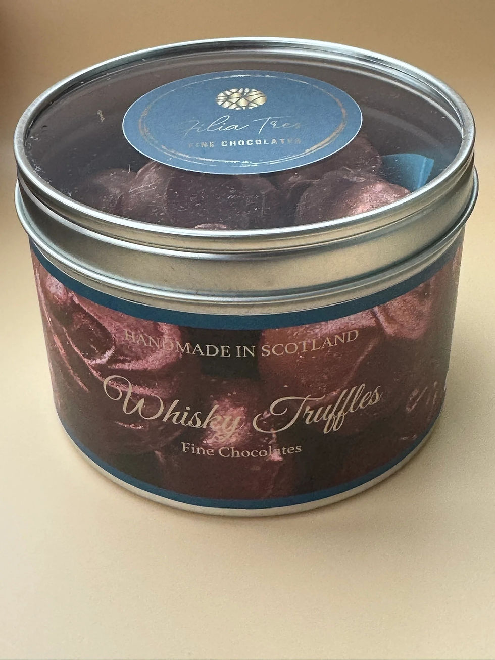 Round metal tin of handmade Scottish whisky truffles with a clear lid