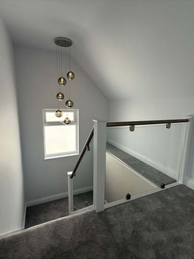 Modern loft conversion staircase with glass balustrade.