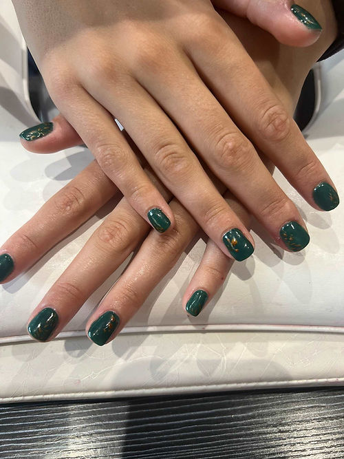 Deep green nails with subtle gold accents
