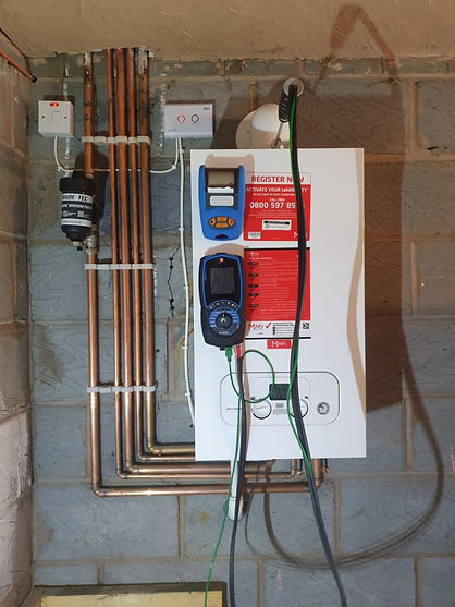 Side-view of a magnetic system filter and external expansion vessel integrated into copper pipework