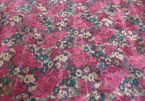 Close up of black satin fabric with small orange floral pattern