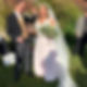 Happy bride and groom celebrating outdoors with drinks and a bouquet